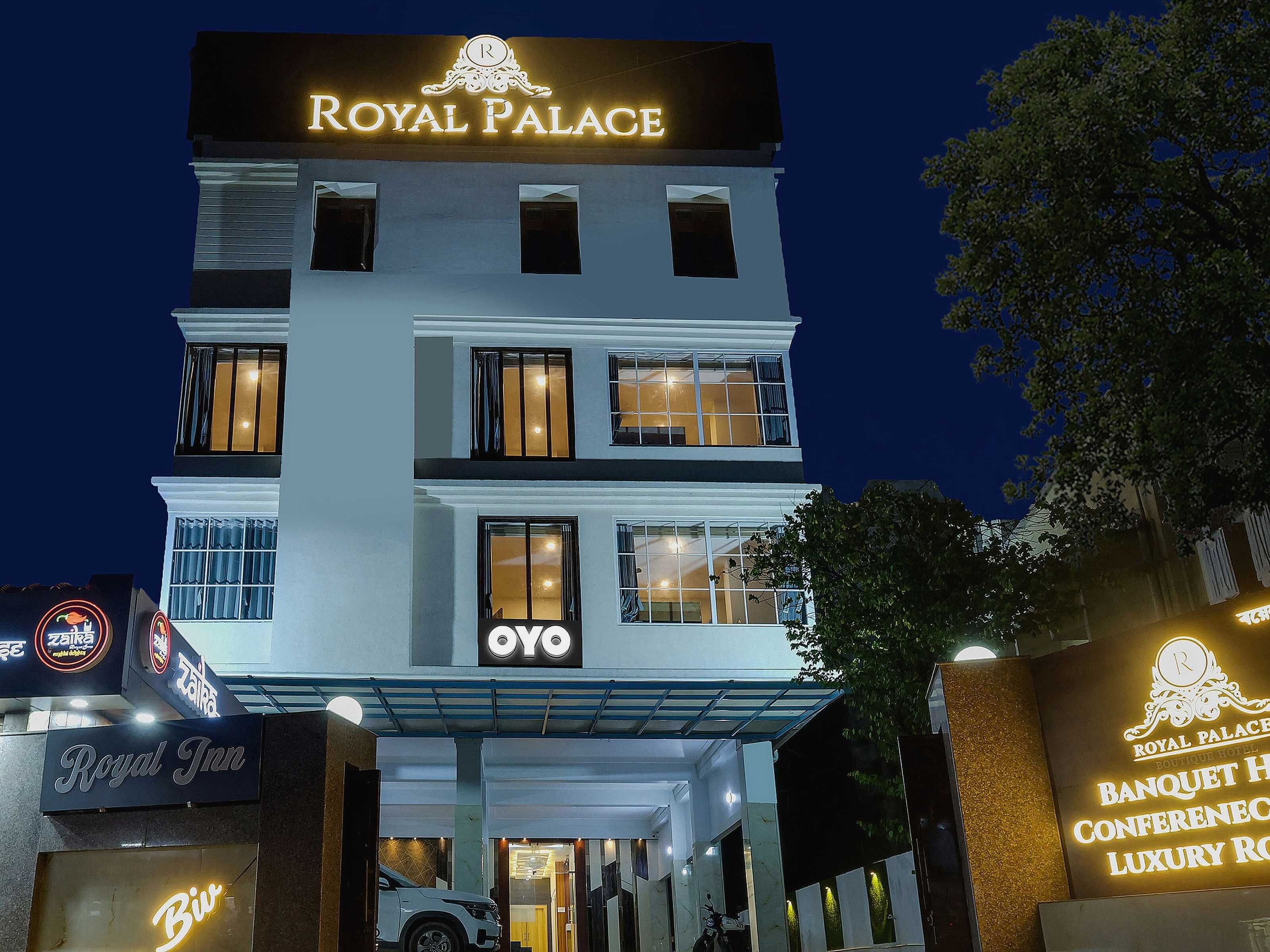 A hotel with a prominent 'ROYAL PALACE' sign, a 'ROYAL INN' sign, and a 'Biw' neon sign.