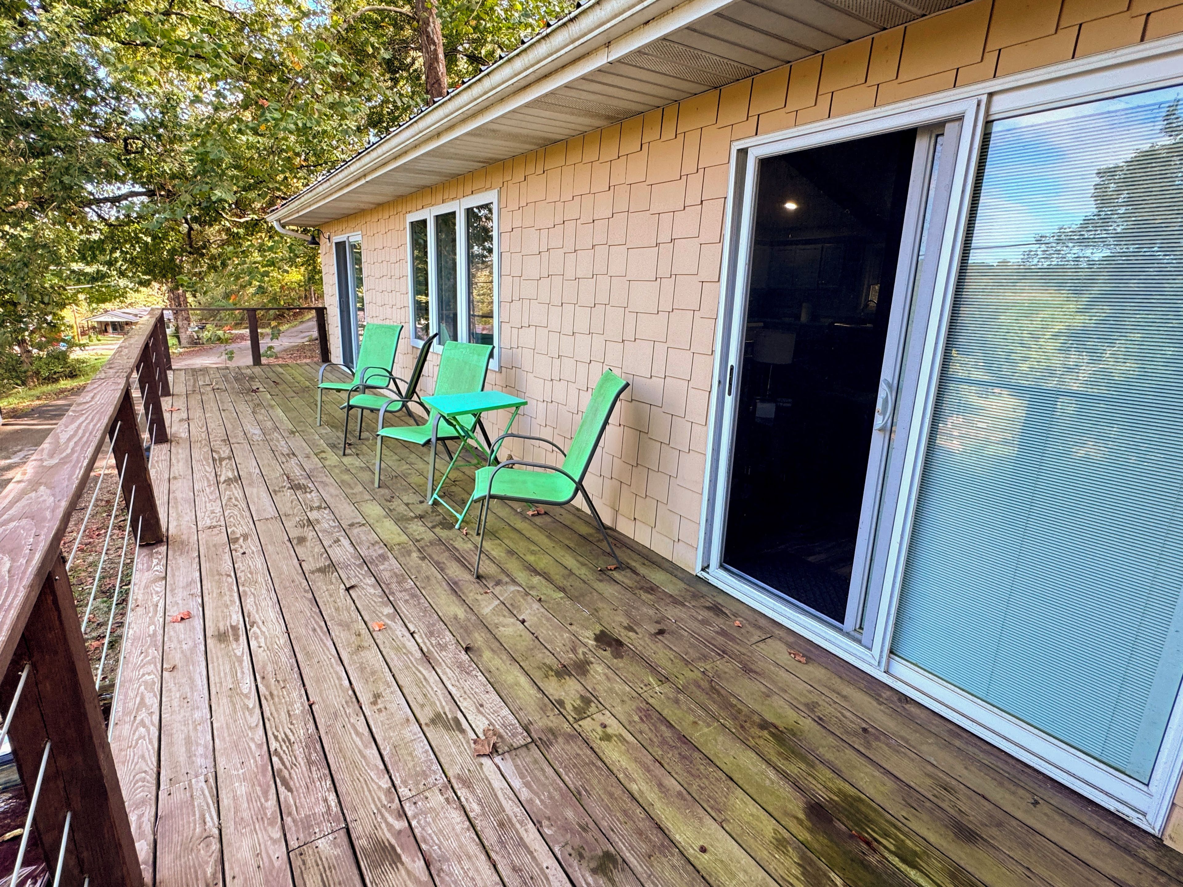 A wooden deck with outdoor seating and a sliding glass door.