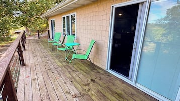 A wooden deck with outdoor seating and a sliding glass door.