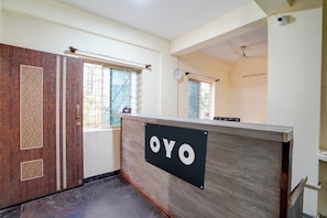 Una recepción con un letrero que dice 'OYO' en el vestíbulo de un hotel.