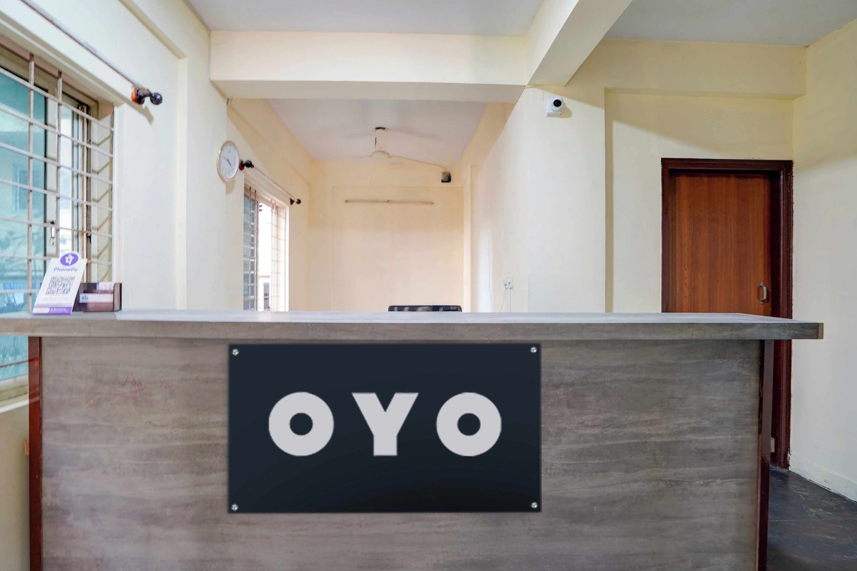Een receptiebalie met een bord waarop 'OYO' staat in de hotelhal.