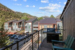 Ein Mehrfamilienhaus mit Grillplatz und Blick auf die umliegenden Hügel.
