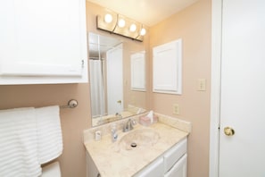 A bathroom with a sink, mirror, and towel rack. - Urban Oasis: In the Medical Center (San Antonio)