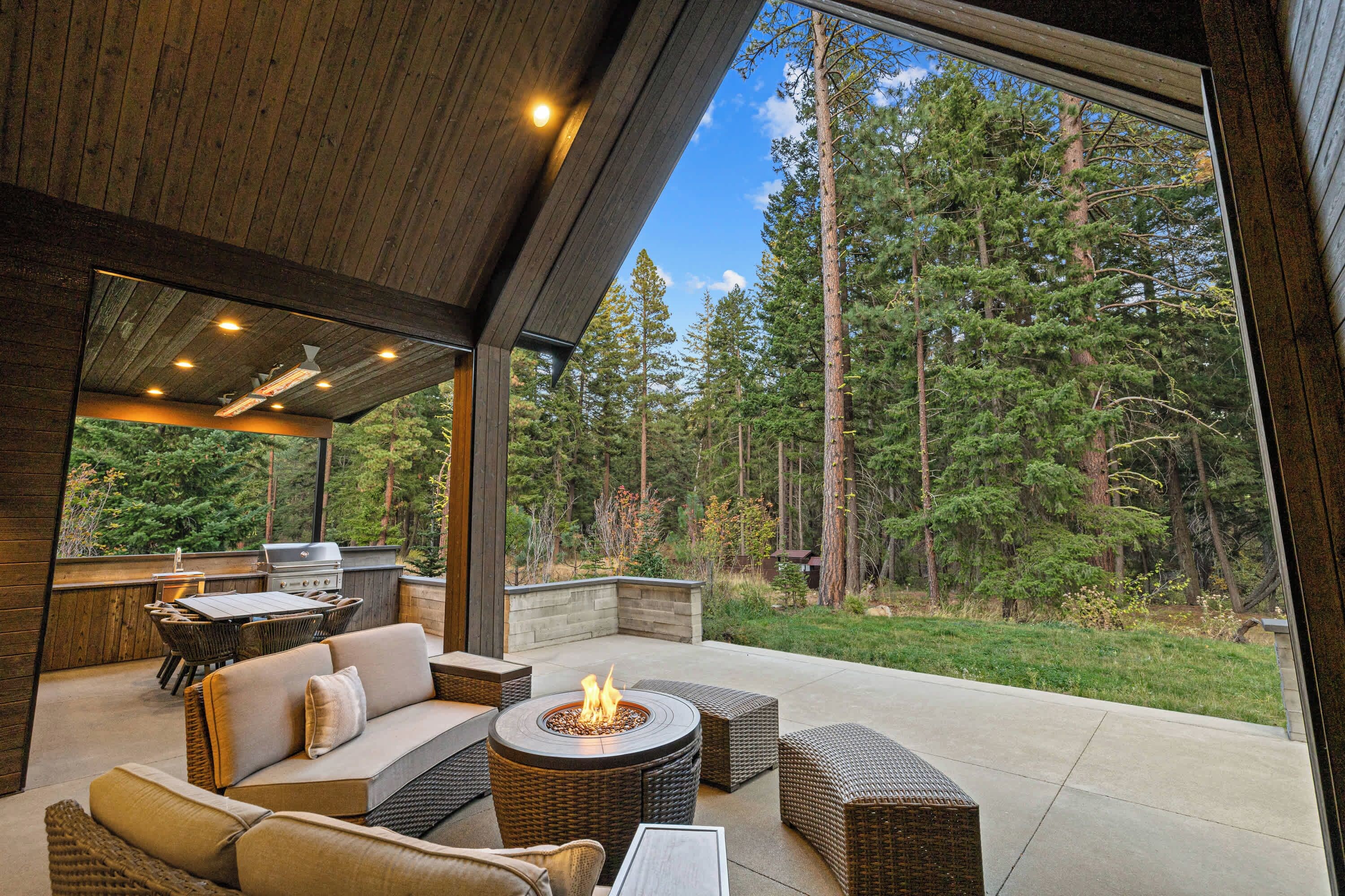 Une terrasse extérieure avec un foyer, des sièges et un barbecue.