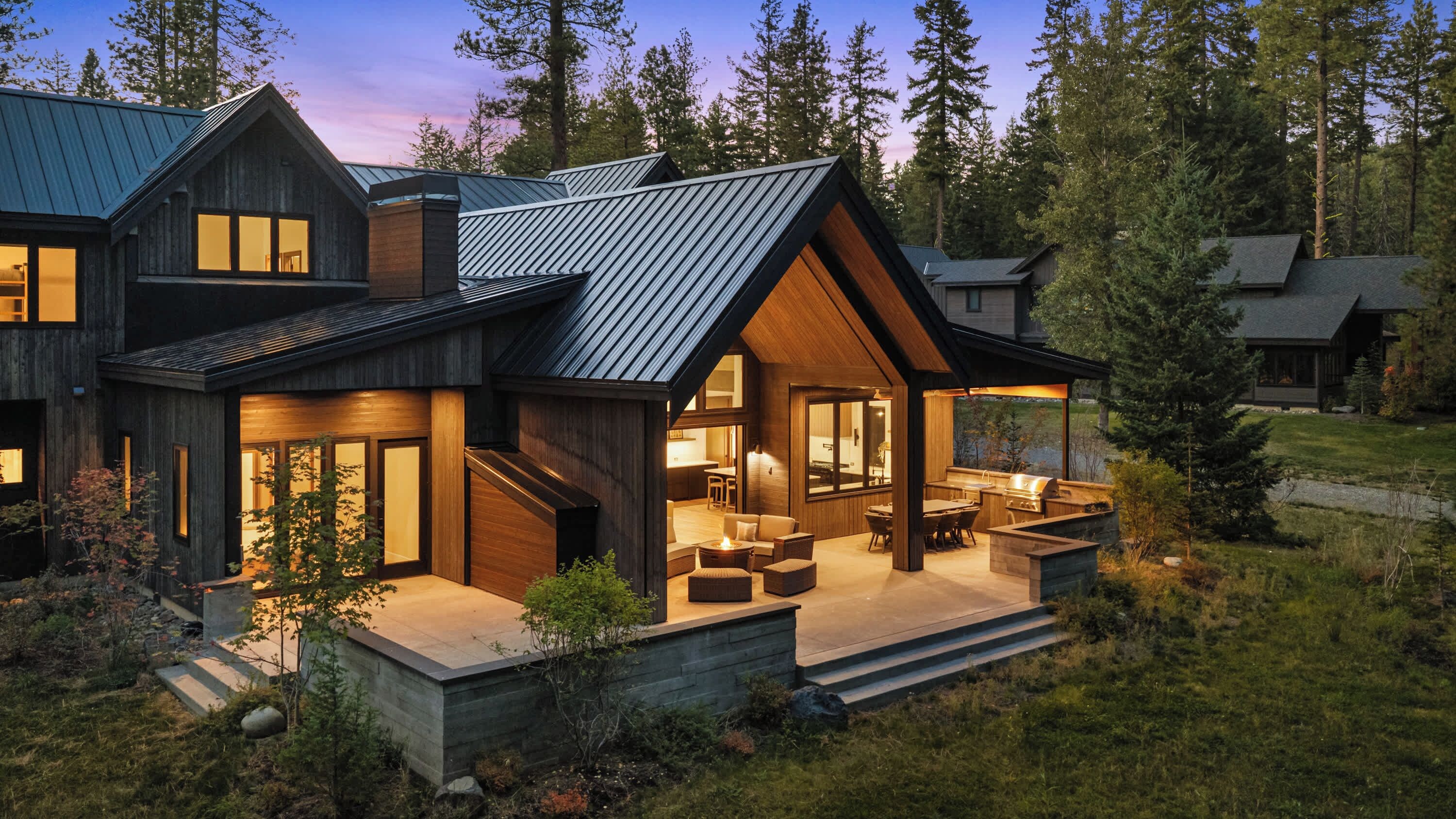 A modern house with a large deck, a covered outdoor kitchen, and a spacious interior.