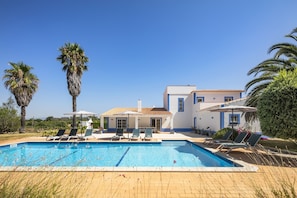 A poolside area with lounge chairs and a swimming pool. - New! Quinta Lamy - Villa with Pool near Carvoeiro (Lagoa)