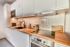 Eine moderne Küche mit Edelstahlgeräten, einer Holzarbeitsplatte und weißen Schränken.