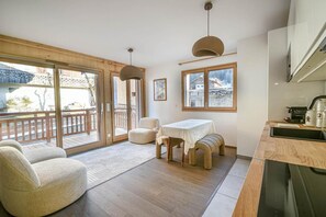 Eine moderne Küche mit Essbereich, Holzboden und großen Fenstern.