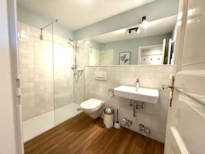 A modern bathroom with a glass-enclosed shower, a white sink, and a toilet. - Deichhof - Apt. 18 (Dunsum)