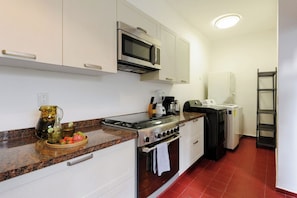 A compact kitchen with a stove, microwave, and a coffee maker. - Timeless Charm in Condesa 6BR, Perfect Terrace (Mexico City)
