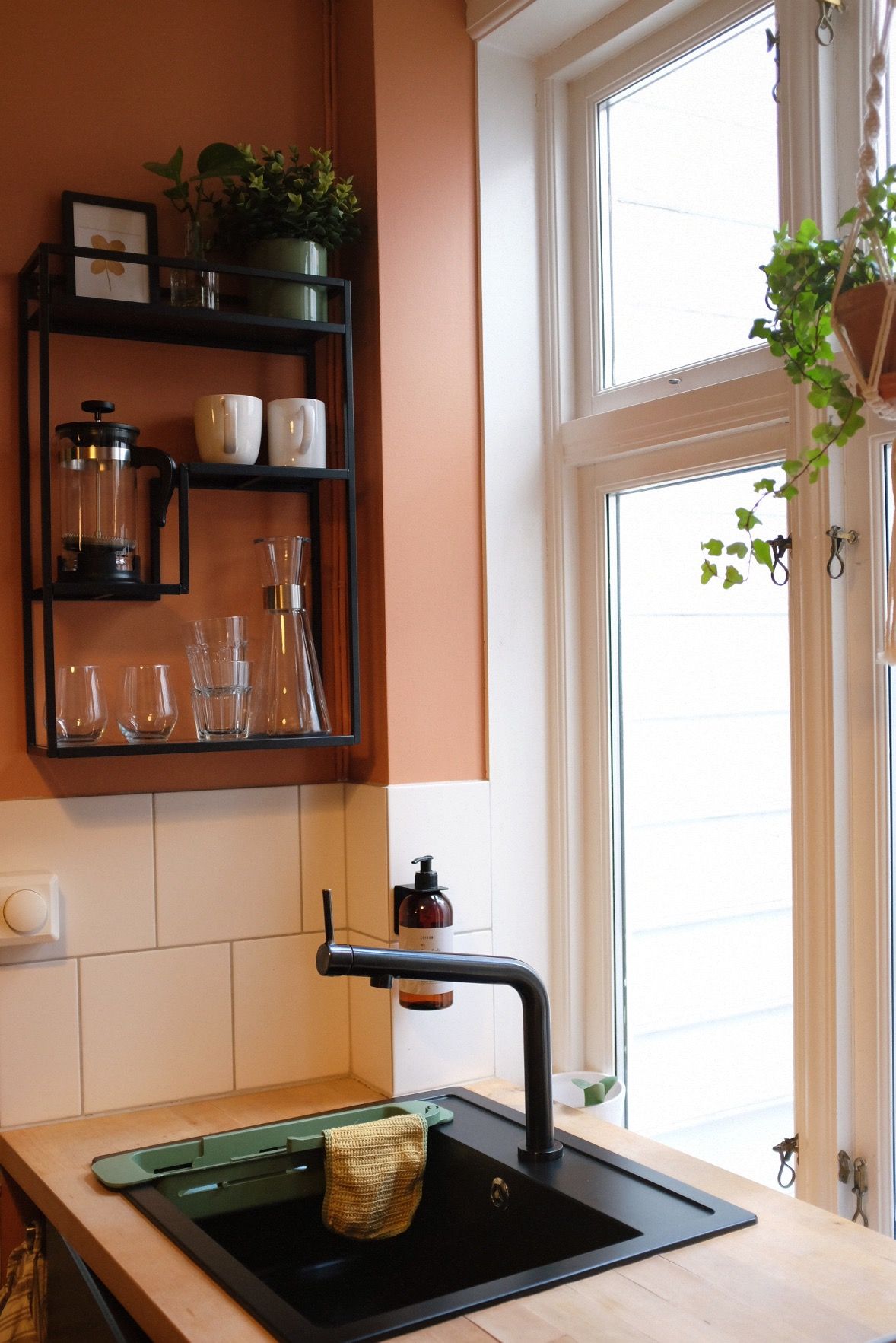 A kitchen with a black countertop, a sink, and a window with a view.
