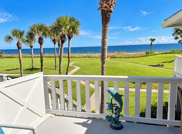 Ein Balkon mit Blick auf einen Golfplatz und das Meer.