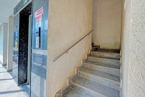 Una escalera con barandilla, un letrero de 'No Fumar' y un letrero que indica 'Use las escaleras'.