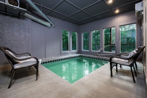 A pool area with two wicker chairs, a tiled floor, and large windows overlooking greenery. - Pappa Bear Splash! 3 Bed w/ Views, Pool & Hot Tub (Sevierville)