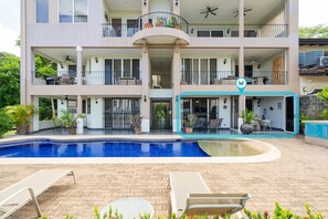 A multi-story residential building with a swimming pool, balconies, and outdoor seating areas. - Beachfront 2 BR/ 2 BA Condo ~ Pool ~ Ground floor – Destino 1-A (Potrero)