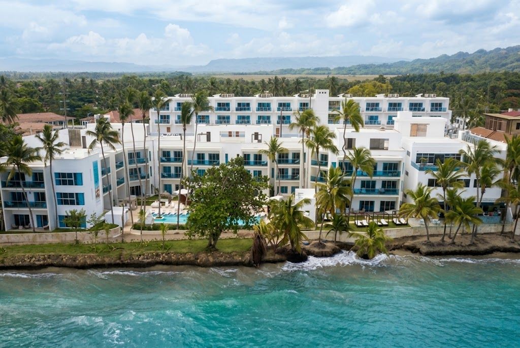 A resort with multiple buildings, a pool, and palm trees.