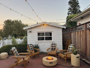 Eine Holzterrasse mit Sitzgelegenheiten und einer Feuerstelle.