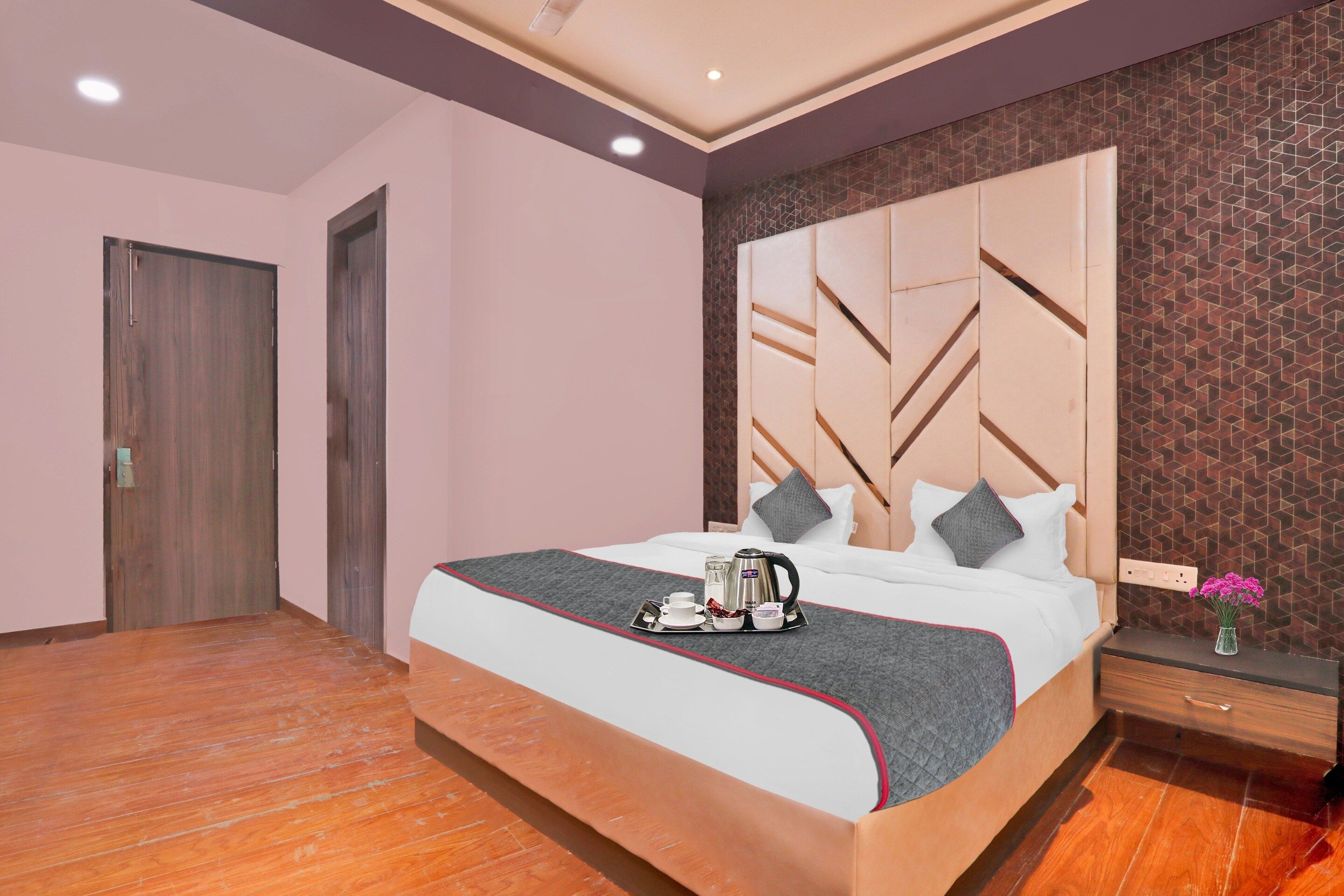 A hotel room with a large bed, a bedside table with a lamp, and a window with a view.