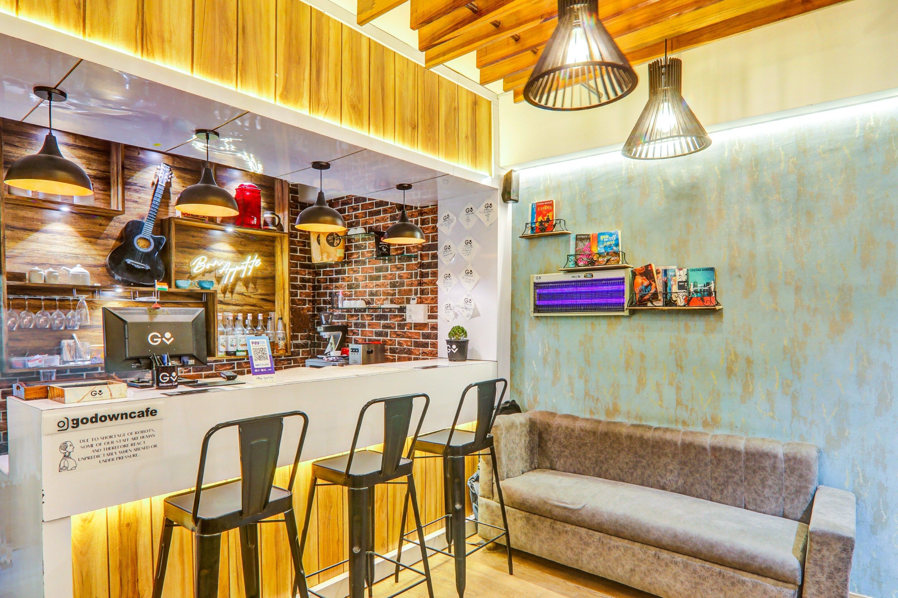 Un café con interior de madera, pared de ladrillo y un sofá.