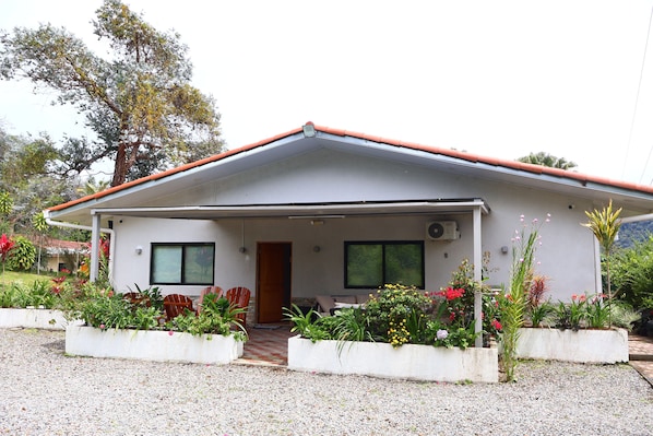 A single-story house with a porch, two windows, and a door. - VILLA ALESSANDRA – TU ESCAPADA PERFECTA EN BAJO BOQUETE (bajo Boquete)