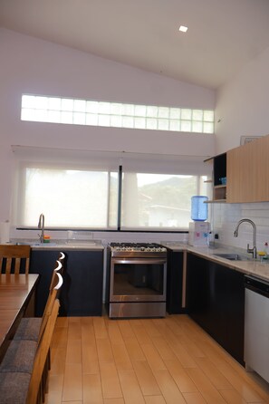 Eine moderne Küche mit Gasherd, Backofen und großem Fenster für natürliches Licht.