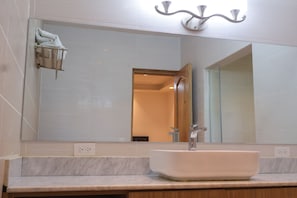 A bathroom with a large mirror, a white sink, and a towel rack. - VILLA ALESSANDRA – TU ESCAPADA PERFECTA EN BAJO BOQUETE (bajo Boquete)