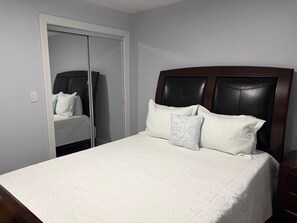 Une chambre à coucher avec un lit, une armoire et une table de chevet.