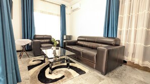 Een woonkamer met een bank, een salontafel en een televisie.