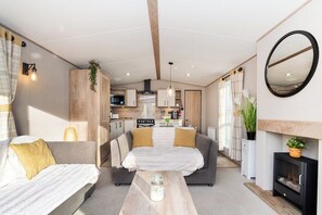 Ein kompakter Wohnbereich mit einer Couch, einem kleinen Tisch, einem Kamin und einer Küchenzeile.