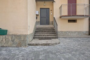 A set of stone steps leading to a door, a metal railing, and a small window on the building's facade. - Apartment 'Aurora Alta' with Balcony, Wi-Fi and Air Conditioning (Maslianico)
