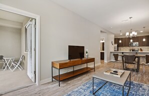 A modern living room with a TV, wooden console, and a dining area with chairs and a table. - Lux 2 Bed Desert Ridge 2 Pools Gym 1 Mile to Mayo Clinic Shops Restaurants (Phoenix)