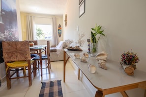 A dining area with a table, chairs, and a view of the outdoors. - Comfortable and peaceful, that's what we call our cozy retreat. (Itacaré)