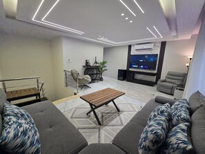 Ein modernes Wohnzimmer mit einer Couch, einem Couchtisch und einem Fernseher.