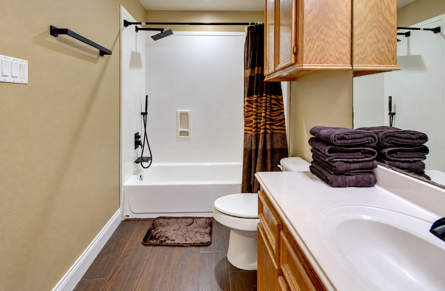 Une salle de bain avec une baignoire, des toilettes et un lavabo, ainsi que des serviettes pliées.
