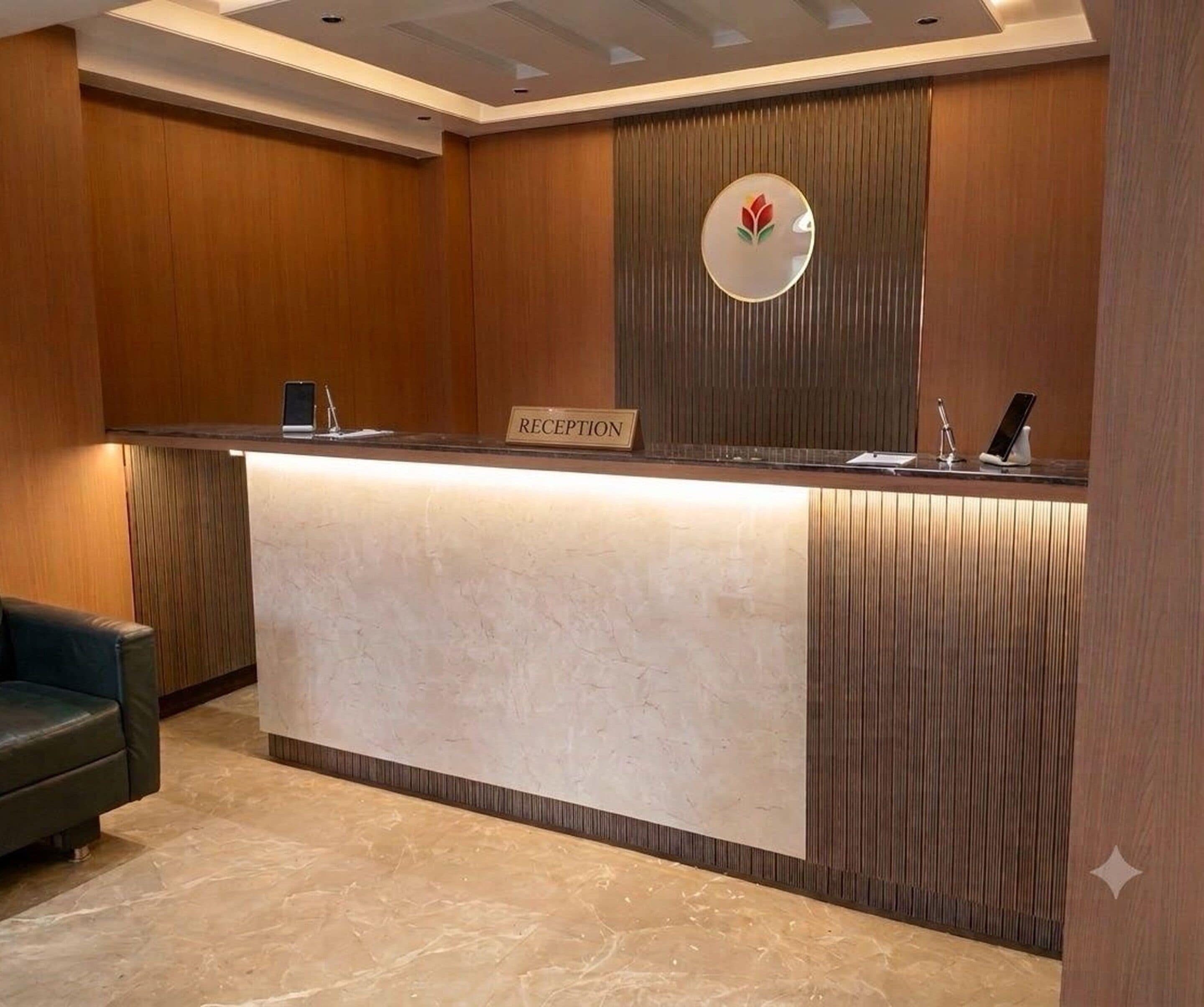 A reception desk with a sign labeled 'RECEPTION,' a phone, and a small table with a pen.