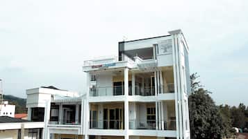 A multi-story building with balconies and a sign indicating 'Silver Land 001 Apartment'.