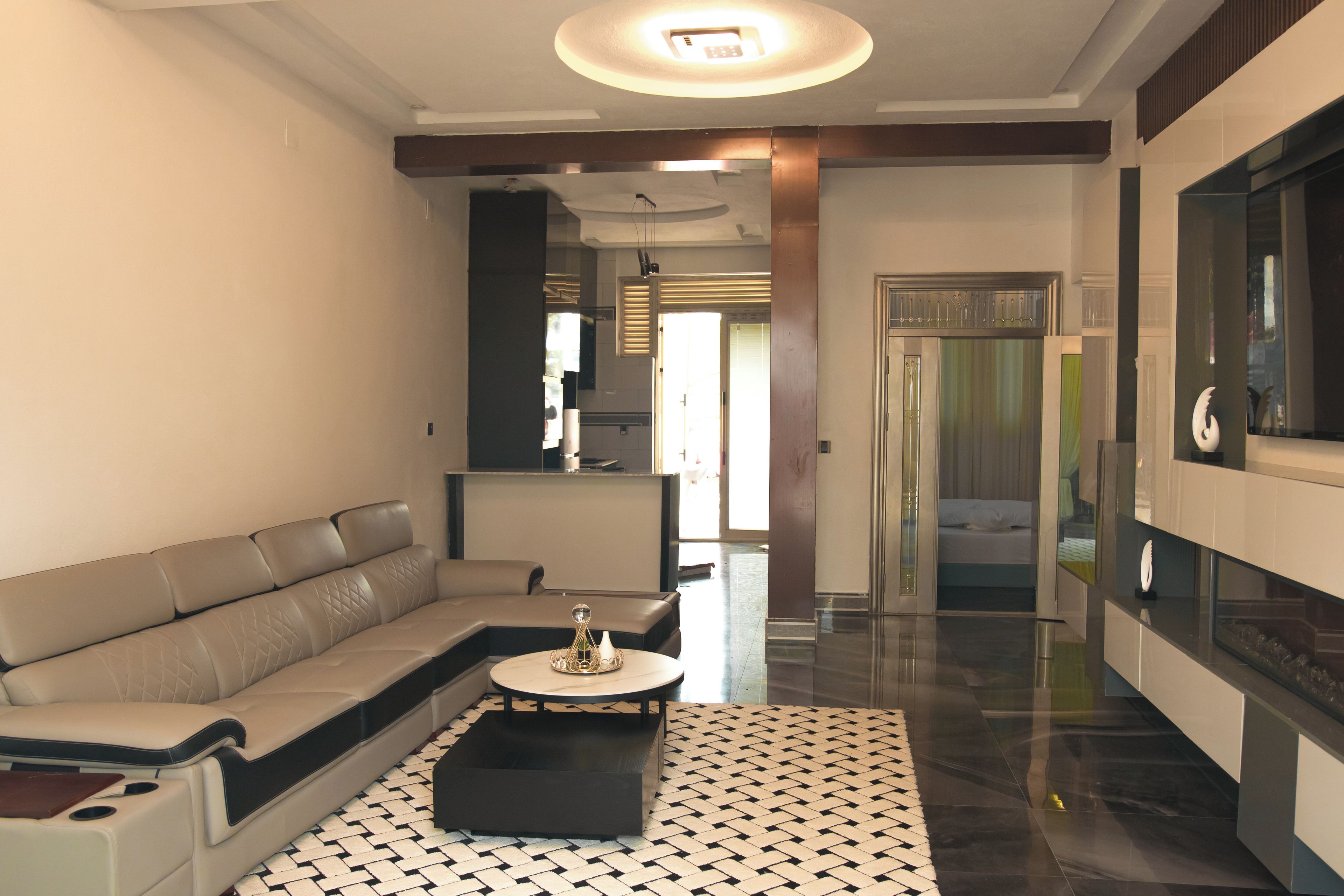 Un salon moderne avec un canapé, une table basse et un tapis à motifs.