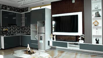 A modern kitchen with a built-in TV, a marble coffee table, and a decorative fireplace.