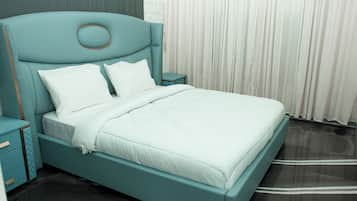 A bed with a headboard, two bedside tables, and a window with curtains.