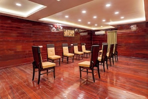 A room with wooden flooring and a row of chairs with cushioned seats. - Townhouse NK Vivanta Luxury Rooms (Sriperumbudur)