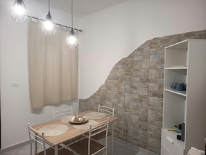 A dining area with a table, chairs, and a hanging light fixture. - Apartment 'La Casa Di Sofi E Greta' with private garden, Wi-Fi and air conditioning (Augusta)