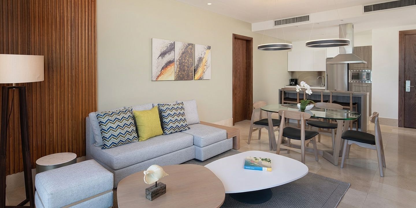 A modern living room with a sofa, coffee table, and dining area.