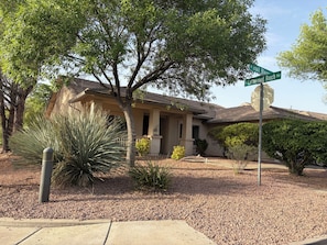 A house with a covered patio, a large tree, and a stop sign. - Perfect 3-bedroom house with AC in  Cottonwood Ranch
Clubhouse with Pool/Hot Tub (Cottonwood)