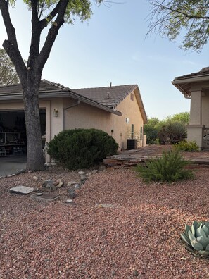 A residential property with a garage, a tree, and a landscaped garden with gravel and plants. - Perfect 3-bedroom house with AC in  Cottonwood Ranch
Clubhouse with Pool/Hot Tub (Cottonwood)