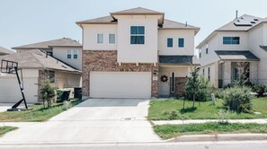 Un quartier résidentiel composé de maisons de plain-pied, chacune ayant une allée et un jardin devant.
