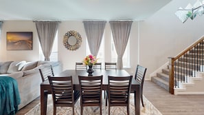 A dining area with a table, chairs, and a vase of flowers. -  Cozy Comfort Home near Randolph AFB, Fort Sam& I 10 -Spacious 5-bedroom house (Converse)