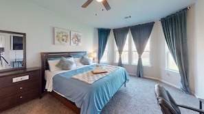 A bedroom with a bed, a desk, a chair, and a ceiling fan. -  Cozy Comfort Home near Randolph AFB, Fort Sam& I 10 -Spacious 5-bedroom house (Converse)