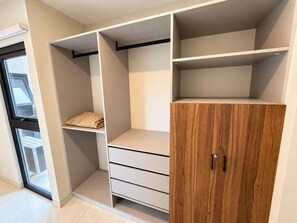 Un armario moderno con estantes abiertos, un mueble de madera y una ventana.