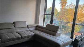 Un sofá modular en una habitación con ventanas amplias.