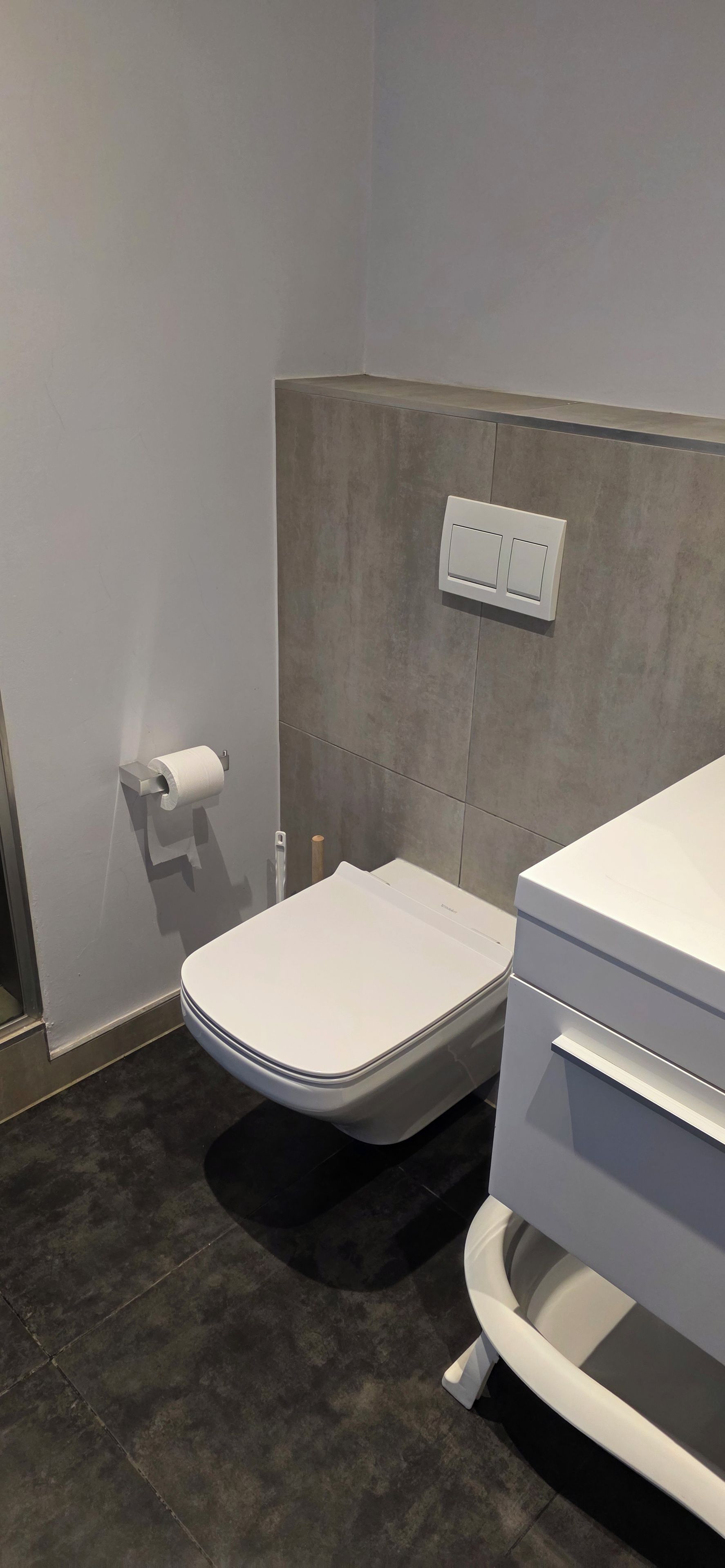 Ein Badezimmer mit Toilette, Waschbecken und Handtuchhalter.